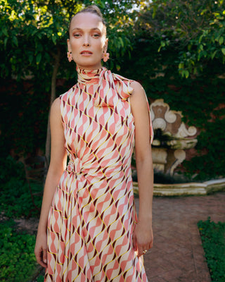 Mujer con vestido midi drapeado, en un jardín con fondo natural